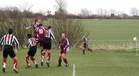 Cussons wins a header in the Acle penalty area